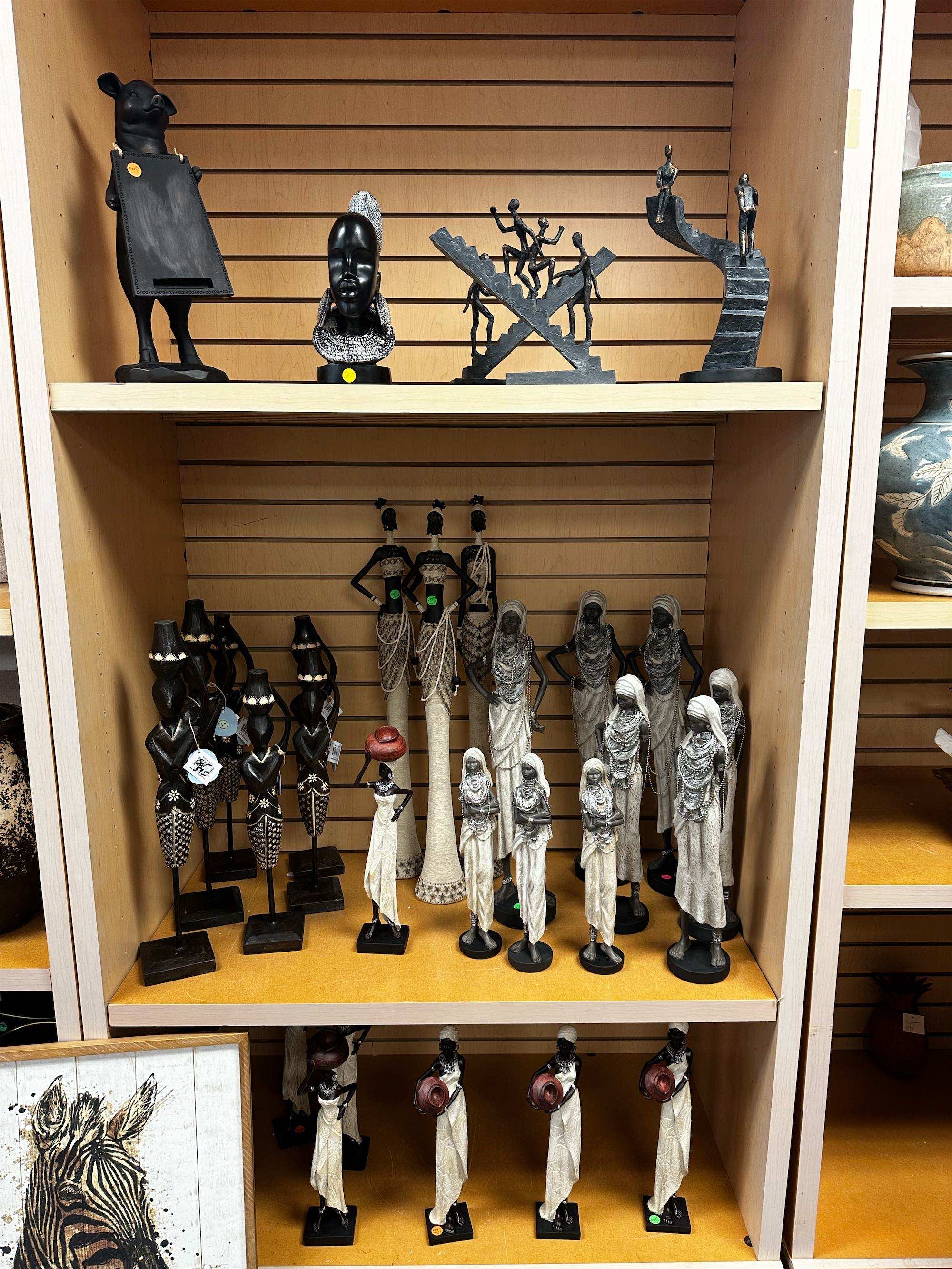 a shelf with statues and vases