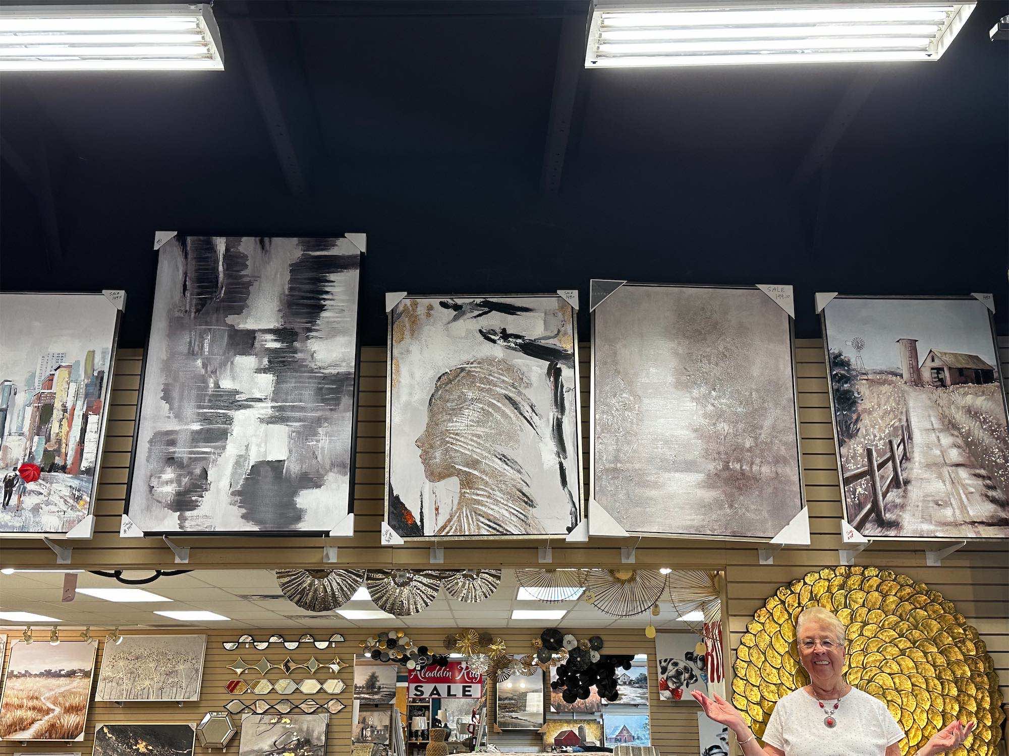 a woman standing in front of a wall of art